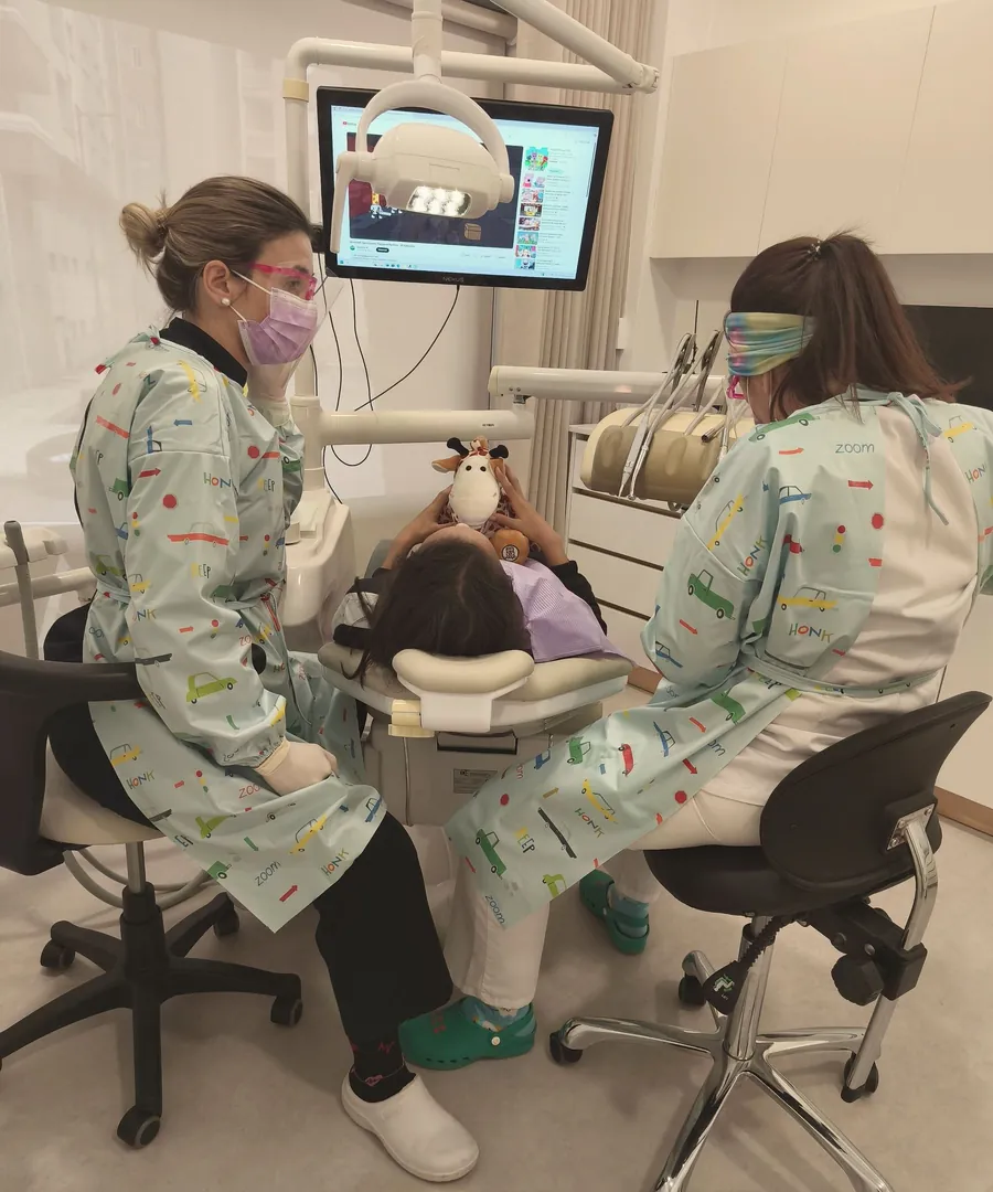 Duas médicas dentistas a tratar uma criança no gabinete