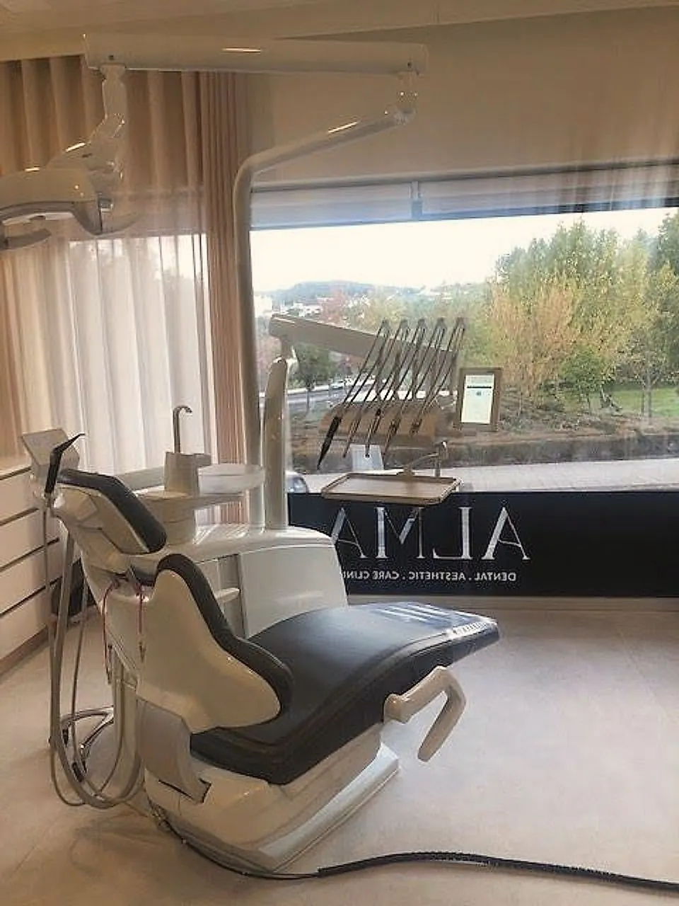 Gabinete de medicina dentária com janela panorâmica e o logo ALMA no vidro